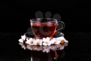 Cup of black tea with and cherry blossom. Copy space background.