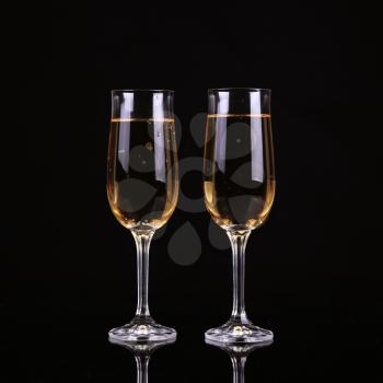 A glass of champagne, on a black background.
