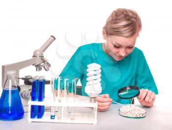 Scientists looking through a microscope.  smiling female scientist analyzing young plants at the laboratory
