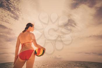 healthy young woman laughing with beachball while on the beach in summer. vacation, sport and people concept - young woman with ball playing volleyball
