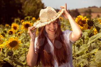 Cute girl in the field full of sunflowers. young beautiful woman on blooming sunflower field in summer