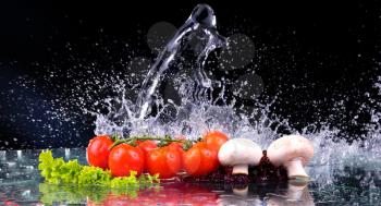 Red tomato cherry, mushrooms and green fresh salad with water drop splash with copy space