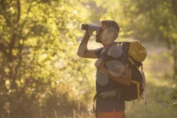 Young Man Traveler with backpack relaxing outdoor with forest on background Summer vacations and Lifestyle concept