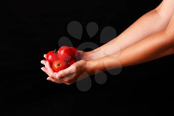 cooking and food concept - female hand  with fork and tomato