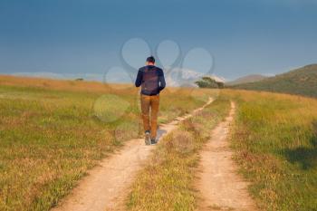 Young man walking on a countryside road.