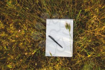Notebook on fresh spring green grass in field