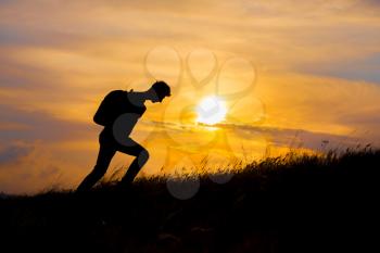 Follow your dreams, silhouette of man at sunset. Hiker with backpack walking in the field. Over sunset. Summer healthy active lifestyle. Single travel.