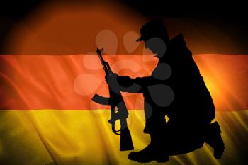 Flag with original proportions. Closeup of grunge flag of Germany with the silhouette of a soldier with a gun