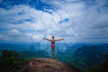 Happy hiker with her arms outstretched, freedom and happiness, achievement in mountains. Thailand, View Point, Nature Trail, Tab Kak Hang Nak Hill