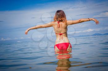 portrait of woman in red swim suit relaxing on tropical beach. Vacation at Paradise. Ocean beach relax, travel to Thailand, Krabi