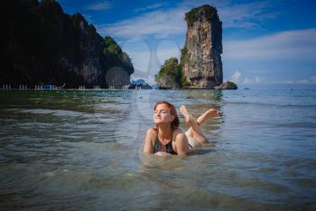 Young fashion woman relax on the beach. Happy island lifestyle. White sand, blue cloudy sky and crystal sea of tropical beach. Vacation at Paradise. Ocean beach relax, travel to Thailand, Krabi, hotel Grand Centara