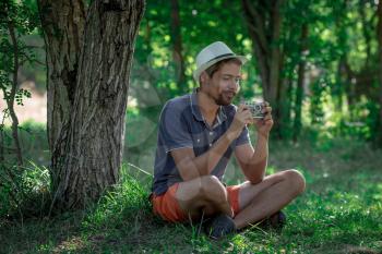 Handsome man with vintage camera in the forest