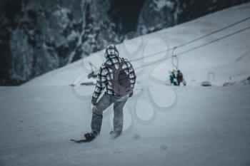Man snowboarder rides on the slope. ski resort. Space for text. ride in Dombay - a downhill skiing resort in Karachayevo-Cherkesiya, Russia.