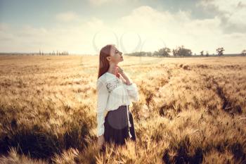 Two young women are looking forward tothe sunset. Best friends. Two young red-haired women in a wheat field