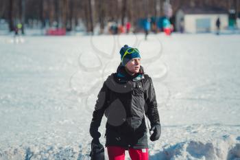 happy young woman in ski goggles outdoors. winter vacation concept. Christmas decorations in a small ski resort. Rest after successful skiing competition.