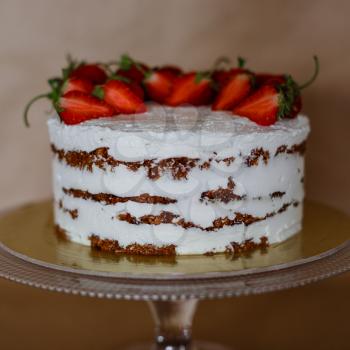 the beautiful cake with strawberries and cream on table. Homemade delicacy. The idea and concept of healthy desserts for those involved in sports and lose weight