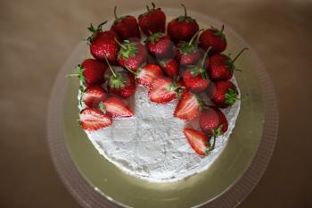 the beautiful cake with strawberries and cream on table. Homemade delicacy. The idea and concept of healthy desserts for those involved in sports and lose weight