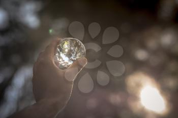 Concept and idea of travel. snow peaks of the alps seen through a glass sphere hold by a hand