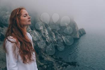 beautiful girl in the morning on the beach. Mysterious girl in the mist, enjoying the humid air. Sudak, Meganom and the New World