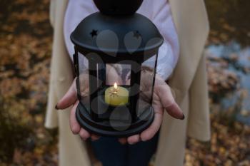 woman's hands Holding black candle lantern in the forest. Fairy magic forest. empty copy space for inscription or other objects.