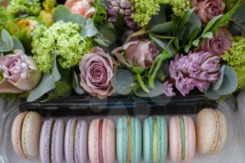 Macaroons in turquoise box with fresh flowers. Stylish powder colors. On the eve of Mother's Day and Women's Day