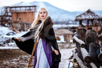Beautiful young woman holding a viking with blond hair. Image of Historical figure