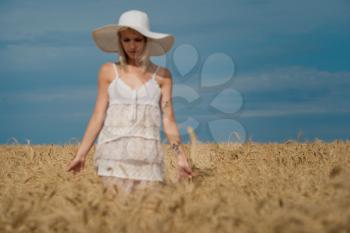 nature, summer holidays, vacation and people concept - face of happy smiling woman or teenage girl n in hat on cereal field