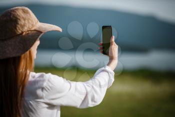 Woman using mobile phone at outdoor. Using a smartphone to navigate the route search, making photos and selfies