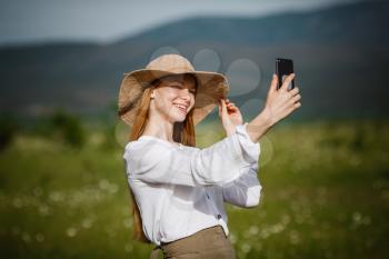 Woman using mobile phone at outdoor. Using a smartphone to navigate the route search, making photos and selfies