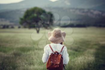 Young red-haired traveler in fairy-tale beautiful scenery. The idea and concept of rest, relaxation, freedom