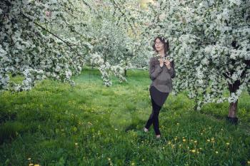 A young pregnant woman in an apple orchard in the heart of Warsaw. Relaxing in the spring in Poland