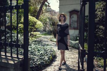 Young beautiful pregnant woman on a walk in Warsaw, Poland. Beautiful old house and a fence