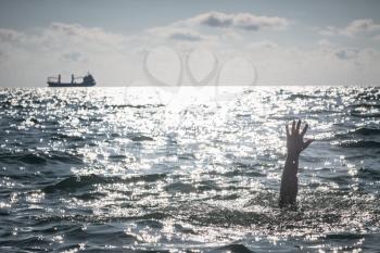 single hand of drowning man in sea asking for help. sticking out of the water