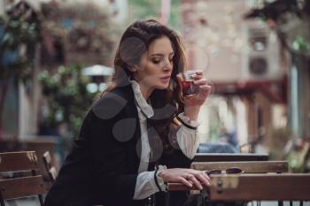 Beautiful woman walks at Istiklal street,a popular location in Beyoglu district,Istanbul,Turkey. woman enjoys favorite drink of the Turks - black tea