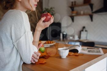 Autumn sseries in the Kitchen, melancholy and warm.. Relaxing in cold weather. red-haired girl enjoying apples in the kitchen