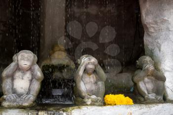 Statue at the Golden Mountain in Bangkok. Three monkeys in the foreground with the famous pose.
