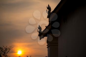 Thai art on roof at Thai temple. Traditional Thai roof. silhouette against the sunset sky