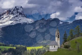 Magnificent summer sunset in Tirol. Chapel of St. Mary Magdalene and the bell tower in the valley of Dolomites.The concept of eco-tourism. Dolomites, Italy, South Tyrol