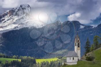 Magnificent summer sunset in Tirol. Chapel of St. Mary Magdalene and the bell tower in the valley of Dolomites.The concept of eco-tourism. Dolomites, Italy, South Tyrol