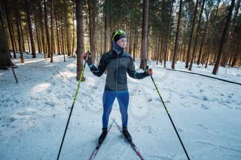 Cross-country skiing woman doing classic nordic cross country skiing in trail tracks in snow covered forest. Training track for skiers in the park of Moscow, Odintsovo