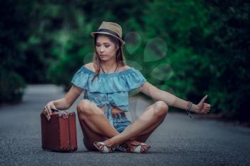 Young beautiful Asian woman in hippy style. travels by hitchhiking. Road in the mountains