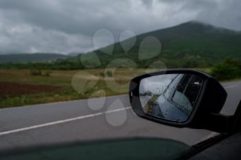 Driving car in the rain on wet road. Rainy weather through the car window. Rain through wind-screen of car. View through the car window in the rain. natura background