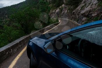 Blue car on wet road in rain at daytime in spring. Transportation. Empty highway in foggy woodland. Trip. travel trip in holiday vacation concept, space