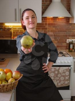 Healthy eating lifestyle concept portrait of beautiful young redhair woman preparing tasty food, holds out an apple