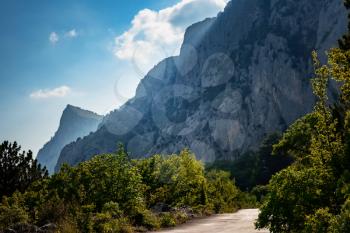 asphalted road in the mountains, beautiful sunshine, summer vacation time. Vintage toning. Travel background. Highway in european mountains