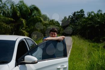 man tourist enjoys the view from the car, the road in Asia. Holiday in summer. man is thinking about this amazing world,