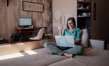 Young attractive woman on sofa working on new project with laptop in home. Attractive businesswoman studying online, using laptop software, web surfing information or shopping in internet store.