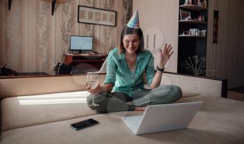 Girl celebrating birthday online in quarantine time through video call virtual party. Coronavirus outbreak 2020.