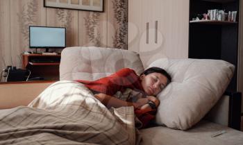 Sick and Flu Woman. Caught Cold. Woman feeling cold with blanket resting on the sofa at home