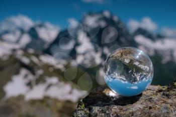 beautiful spherical glass ball with majestic Caucasian mountains, Dombai, Russia. the idea and concept of discovery, travel and trekking, Hiking theme.